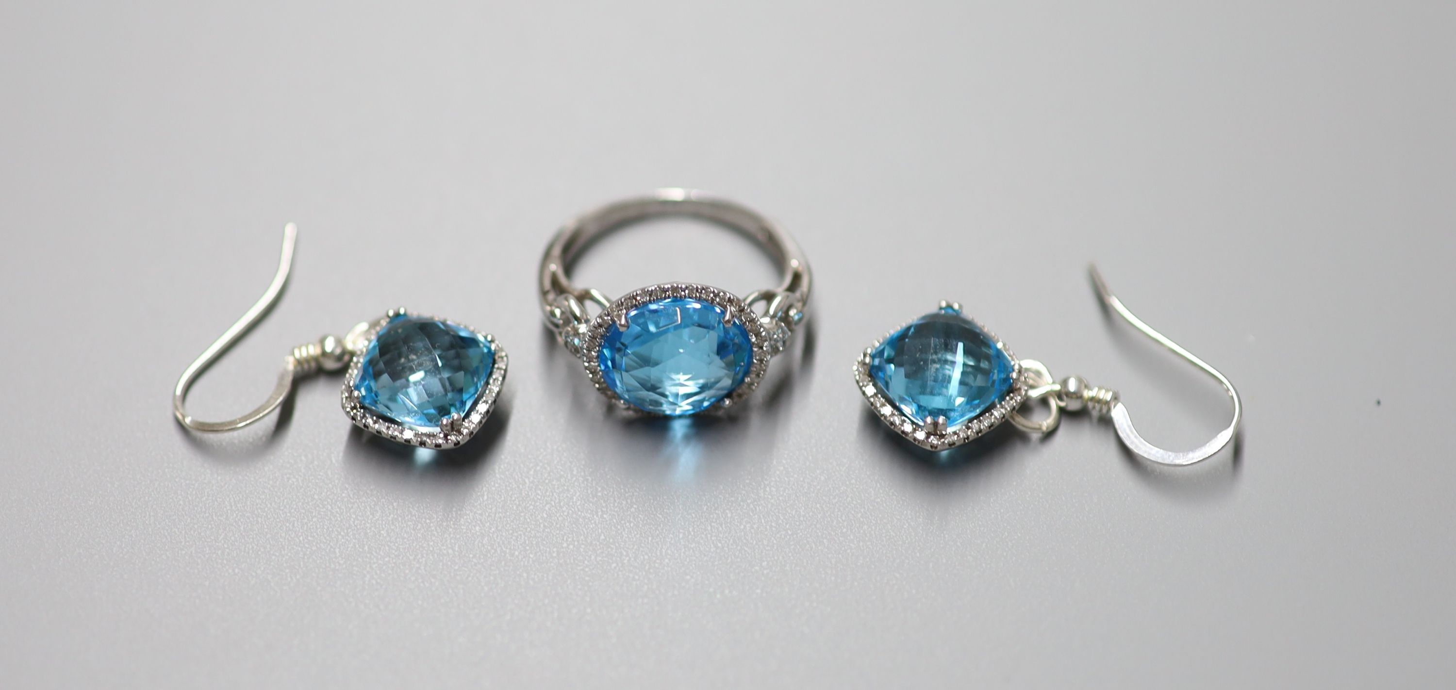 A modern 18ct white gold, blue topaz and diamond chip set dress ring, size L/M, gross 5 grams and a similar pair of drop earrings, stamped 375, gross 5 grams.